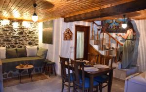 a room with a table and a woman walking up the stairs at Kactro House in Samothraki