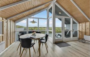 a dining room with a table and chairs at Holiday Home Sdr Klitvej Hvide Sande in Havrvig