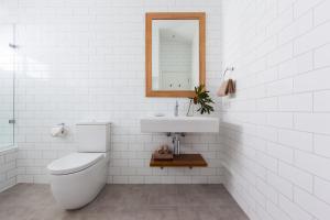 a white toilet sitting next to a bathroom sink at The Beach Shack Byron Bay in Byron Bay
