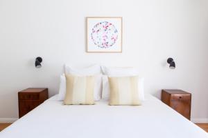 a white bed with two pillows on top of it at The Beach Shack Byron Bay in Byron Bay