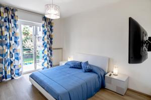 a bedroom with a blue bed and a flat screen tv at Residenza La Ruota Tulipano in Arona