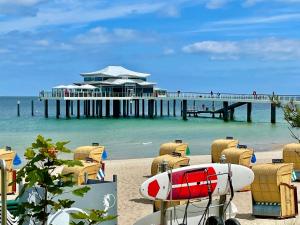 a pier with chairs and a surfboard on the beach at Country Hotel Timmendorfer Strand in Timmendorfer Strand