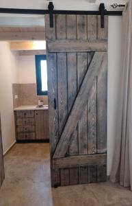a large wooden door in a room with a sink at Studio Zoi in Matala +6 photos