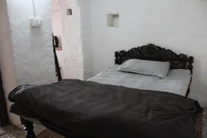 a bed with a black headboard in a room at Swami Rama Initiative in Rīthākhāl