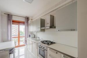 a white kitchen with a stove and a window at Miranda - Apartament in Mestre with Balcony! in Marghera