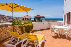 a patio with a table and chairs and an umbrella at Apartment Chateau Morro 7 in Morro del Jable