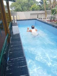 a man is swimming in a swimming pool at Asian Grand Villa in Bolpur