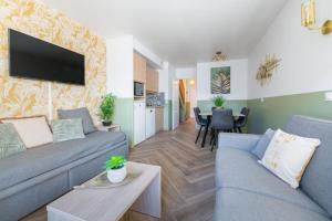 a living room with a couch and a table at Jungle Duplex with pool 5 min Disneyland in Serris