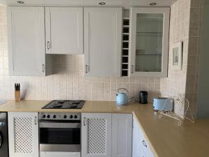 a kitchen with white cabinets and a stove at Your own space in the leafy Cape in Cape Town +12 photos