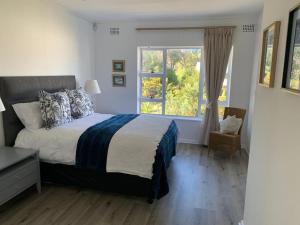 a bedroom with a large bed and a window at Your own space in the leafy Cape in Cape Town