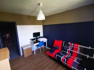 een woonkamer met een bank en een bureau met een computer bij Olympiades in Annecy