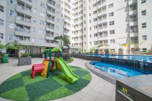 a playground with a slide next to a pool at Strategic and Comfortable 2BR Apartment at Gateway Pasteur By Travelio in Bandung