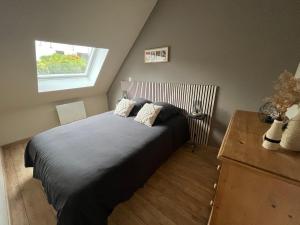 Un dormitorio con una cama grande y una ventana. en Gîte Le Phoenix entièrement neuf, en Wimereux
