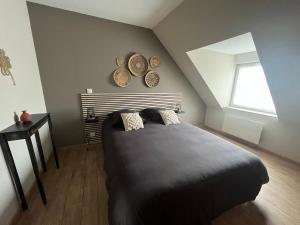 Un dormitorio con una cama grande y una ventana. en Gîte Le Phoenix entièrement neuf, en Wimereux