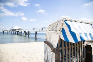 a bench on the beach next to a pier at Country Hotel Timmendorfer Strand in Timmendorfer Strand