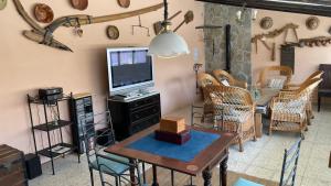 a living room with a tv and a table and chairs at Los Cipreses de Mesones in Mesones