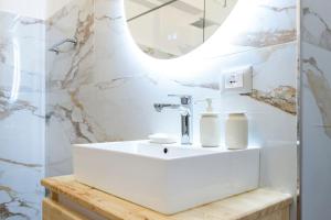 a bathroom with a white sink and a mirror at Saint 40 Suites Premium Flat in Sarandë +27 photos