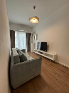 a living room with a couch and a television at Saint 40 Suites Premium Flat in Sarandë