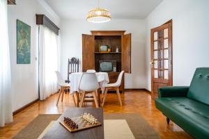 sala de estar con mesa y sofá verde en Casa da Professora Ponte de Lima, en Refoios do Lima