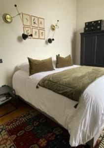 een slaapkamer met een groot bed met 2 lampen aan de muur bij Appartement 2pers «Le Parisien » in Saint-Omer