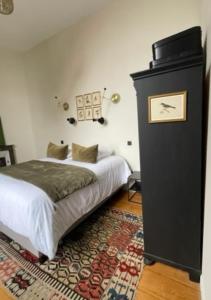 een slaapkamer met een bed en een klok aan de muur bij Appartement 2pers «Le Parisien » in Saint-Omer +6 foto's