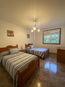 a bedroom with two beds and a window at Casa SobreMonte in Muxia