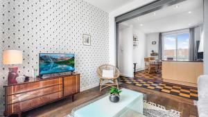 salon z telewizorem i kanapą w obiekcie HOMEY COLOC GATSBY - New, parking gratuit, proche gare, Balcons privés, Établissement élégant et moderne w mieście Ville-la-Grand
