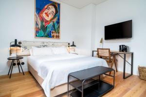 a bedroom with a white bed and a flat screen tv at Limehome Porto Rua Das Oliveiras in Porto +42 photos