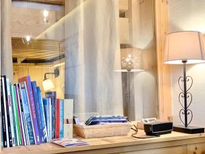 a shelf with two lamps and books on it at Homency - Résidence Ménandière E6 in L'Alpe-d'Huez