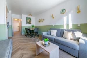 a living room with a blue couch and a table at Jungle Duplex with pool 5 min Disneyland in Serris