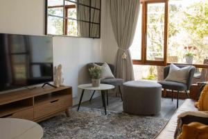 a living room with a couch and a tv at Your own space in the leafy Cape in Cape Town