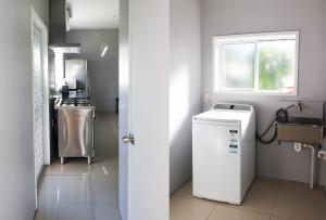 una piccola cucina con lavatrice e finestra di Inave Holidays a Rarotonga