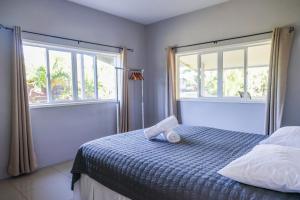una camera da letto con un letto con un paio di finestre di Inave Holidays a Rarotonga