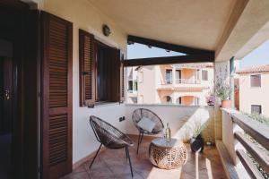a patio with two chairs and a table on a balcony at Cactus Mare Apartment in Golfo Aranci