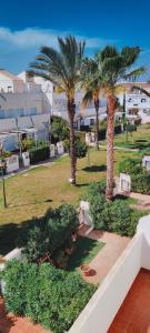 vistas a un parque con palmeras y bancos en Dúplex Buganvillas, en Los Amarguillos 12 fotos más