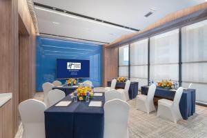 a conference room with tables and chairs and a tv at Holiday Inn Express Xi'an Daxing by IHG in Xi'an