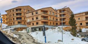 a large wooden building in the snow in front at Nassfeldpass Pistenblick in Sonnenalpe Nassfeld
