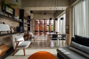 a living room with a table and chairs at The Hotel Journal Chiangmai in Chiang Mai