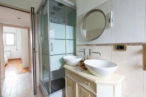 a bathroom with two sinks and a shower at EasyTopStay - San Siro Large Flat in Milan +18 photos