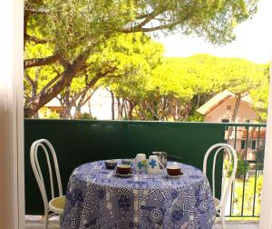 a table with a blue and white table cloth on a balcony at Residence delle Nazioni - Spiaggia privata su richiesta in Principina a Mare