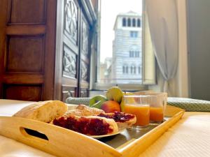 een dienblad met eten, brood, fruit en sinaasappelsap bij Happy Family Apartments Cathedral in Genua +19 foto's