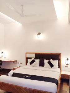 a bedroom with a bed and a desk in a room at Stays - Golf Course Road in Gurgaon