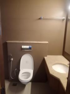 a small bathroom with a toilet and a sink at Stays - Golf Course Road in Gurgaon +35 photos