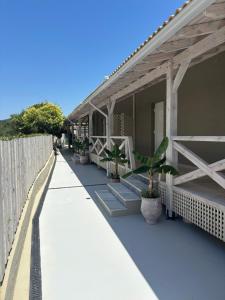 une terrasse couverte d'une maison avec des plantes en pot dans l'établissement Via Polonia - Boutique Studios Corfu, à Ágios Geórgios