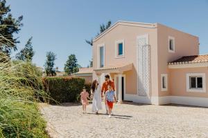 una familia caminando hacia una casa en Vale da Lapa Village Resort, en Carvoeiro