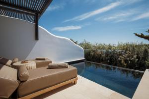 a living room with a couch and a swimming pool at Asty Mykonos Hotel & Spa - World of One Hotel Group in Mikonos