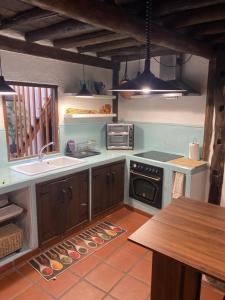 a kitchen with a sink and a stove top oven at Casa Rural Cerro del Mariscal in Sequeros