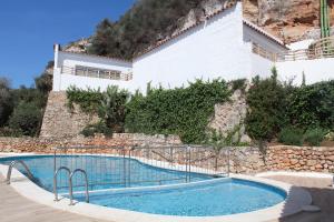 a swimming pool in front of a building at Osprey Menorca Hotel in Cala en Porter
