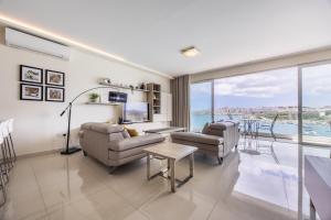 un salon avec deux canapés et une grande fenêtre dans l'établissement Avalon by the Sea - A Breath of Oceanfront Luxury, à Sliema 17 autres photos
