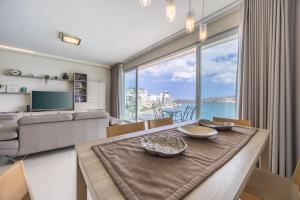 un salon avec une table et une grande fenêtre dans l'établissement Avalon by the Sea - A Breath of Oceanfront Luxury, à Sliema